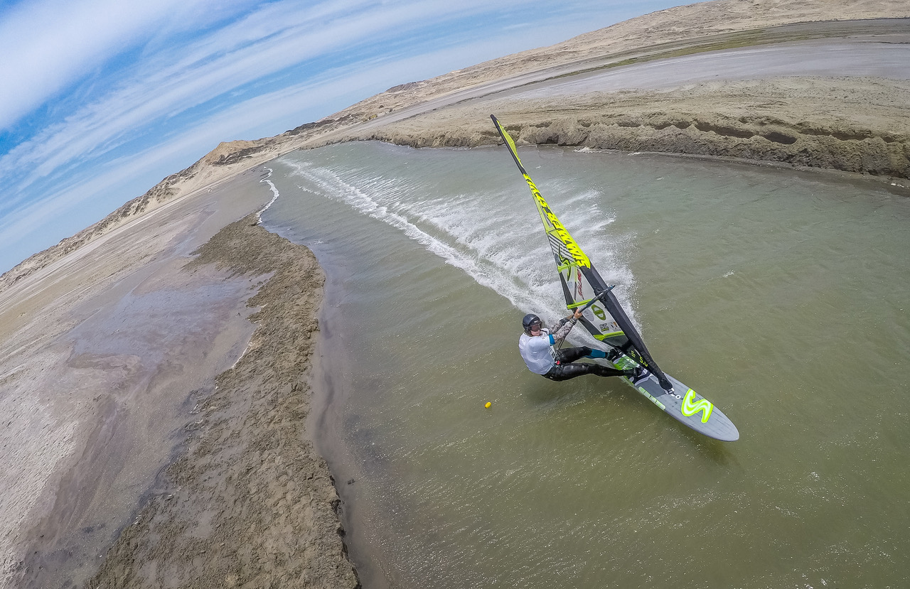 Aerial view of a windsurfer on a narrow strip of water